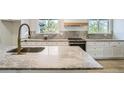 Close-up of the kitchen counter featuring white cabinets and stainless-steel appliances at 8463 W Arizona Dr, Lakewood, CO 80232