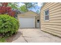 View of detached garage with white door and cracked concrete driveway at 2921 S Holly Pl, Denver, CO 80222