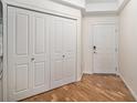 Bright hallway featuring wood floors, ample closet space, and neutral paint at 1044 Rockhurst Dr # 207, Highlands Ranch, CO 80129