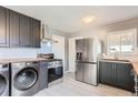 Open kitchen with stainless steel appliances and new front loading washer and dryer at 755 Newark St, Aurora, CO 80010