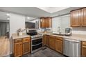 Bright kitchen showcasing stainless steel appliances, oak cabinets, granite countertops, and modern fixtures at 4028 S Atchison Way, Aurora, CO 80014
