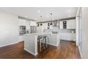 Bright, open kitchen with white cabinetry, a large island, stainless steel appliances, and hardwood floors at 11023 Pastel Pt, Parker, CO 80134