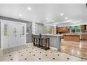 Spacious entryway featuring tile flooring, a decorative front door, and views into the kitchen at 1945 Yarrow St, Lakewood, CO 80214