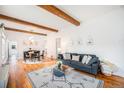 Open living and dining area with hardwood floors and exposed beams at 3403 N Raleigh St, Denver, CO 80212