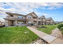 Multi-level townhomes featuring stone accents, covered porches and pristine landscaping at 10818 Cimarron St # 206, Firestone, CO 80504