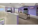 Living room with fireplace and purple accent wall, with sliding doors to the deck at 10818 Cimarron St # 206, Firestone, CO 80504