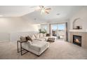 Bright living room boasts neutral tones, a fireplace, and access to an outdoor balcony area at 10818 Cimarron St # 206, Firestone, CO 80504