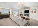Inviting living room features a fireplace, a ceiling fan, and sliding door access to the outdoor space at 10818 Cimarron St # 206, Firestone, CO 80504
