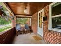 Inviting front porch with brick walls, rocking chairs, and a 'hello' welcome mat at 3622 Lowell Blvd, Denver, CO 80211