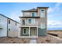 Inviting three-story home featuring a charming balcony and well-maintained landscaping, creating a welcoming facade at 13586 E 103Rd Pl, Commerce City, CO 80022