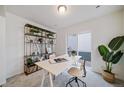 Well-lit office space featuring large desk, modern shelving, and sliding door to the outside at 13586 E 103Rd Pl, Commerce City, CO 80022