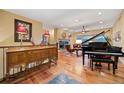 Elegant living room featuring a grand piano, fireplace, and unique decor at 5118 Bottlebrush Run, Broomfield, CO 80023