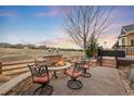 Inviting outdoor patio with a stone fireplace and comfortable seating, perfect for relaxing and entertaining at 5118 Bottlebrush Run, Broomfield, CO 80023