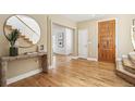 Bright foyer with hardwood floors, staircase, console table with decor, and access to other rooms at 1290 S Milwaukee St, Denver, CO 80210