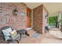 Inviting front porch with brick accents, seating area, and decorative wreath on the wooden front door at 1290 S Milwaukee St, Denver, CO 80210