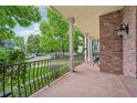 Spacious front porch with brick detailing, iron railing, comfortable seating, and views of the landscaped yard at 1290 S Milwaukee St, Denver, CO 80210