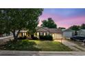 Charming single-Gathering home with a well-maintained lawn, mature trees and an attached garage during sunset at 7550 Raleigh St, Westminster, CO 80030