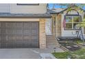 Exterior shot highlighting front door, garage, steps, and partial front yard with lawn at 690 Howe Ct, Castle Rock, CO 80104