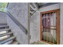 Close-up of the condo's entrance showing a secure screen door and a flight of stairs at 6420 S Dayton St # J07, Englewood, CO 80111