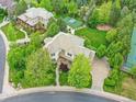 Expansive property with lush landscaping, basketball court, sand pit, and a grand home featuring a tile roof at 291 Fairchild Dr, Highlands Ranch, CO 80126