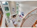 Grand living room with soaring ceilings, large windows, fireplace, and elegant staircase with wood railing at 291 Fairchild Dr, Highlands Ranch, CO 80126
