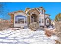 Beautiful home with stone accents, large windows, and snowy front yard, offering curb appeal and natural light at 6943 Saddleback Ave, Firestone, CO 80504