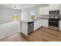 Open concept kitchen features stainless appliances, island, granite countertops and wood flooring at 2214 Alyssa St, Fort Lupton, CO 80621