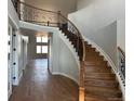 Grand foyer with hardwood floors, staircase, iron railing, and open floor plan with lots of light at 13350 Imboden Rd, Hudson, CO 80642