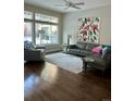 Sunlit living room with hardwood floors, a large window, and comfortable gray sofa at 8717 Forrest Dr, Highlands Ranch, CO 80126