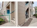 View of the condo's exterior with access to the balcony, a small patio, and landscaping at 8415 Pebble Creek Way # 102, Highlands Ranch, CO 80126