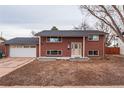 Charming two-story red brick home with a well-maintained lawn and inviting front entrance at 889 Douglas Dr, Denver, CO 80221
