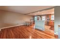 Inviting living room featuring hardwood floors flowing into an updated kitchen, bright and open at 889 Douglas Dr, Denver, CO 80221