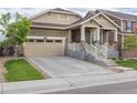 Inviting home with a spacious driveway leading to a two-car garage, complemented by green landscaping at 22820 E Chenango Ave, Aurora, CO 80015