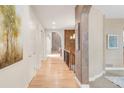 A bright hallway featuring an elegant archway, hardwood floors, and fresh white trim at 3143 Elmira St, Denver, CO 80238