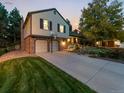 Well-maintained two-story home with brick and siding exterior, two-car garage, and lush front lawn in a suburban setting at 7668 S Locust St, Centennial, CO 80112