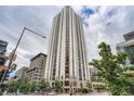 Striking high-rise building featuring modern architecture, balconies, and a vibrant urban setting with green spaces and pedestrian areas at 1625 Larimer St # 1104, Denver, CO 80202