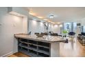 Bright, open-concept living room featuring hardwood floors, city views, a granite bar, and modern decor at 1625 Larimer St # 1104, Denver, CO 80202