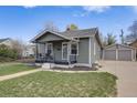 Charming home featuring a covered front porch, well-maintained lawn, and detached two-car garage at 4478 S Acoma St, Englewood, CO 80110
