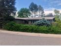 Traditional one-story house with a well-manicured yard, mature hedges, and brick exterior at 3001 S Vine St, Denver, CO 80210