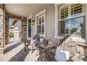 Cozy front porch with stone accents, seating and views of the neighborhood at 493 Pine Flower Ct, Highlands Ranch, CO 80126