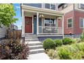 Inviting front porch with decorative hanging plants and a vibrant red front door at 12740 Tamarac St, Thornton, CO 80602