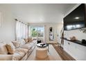 Bright living room with large window, comfortable seating, and modern decor at 12740 Tamarac St, Thornton, CO 80602