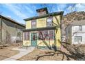 Inviting two-story home featuring a yellow exterior and surrounded by mature trees at 1918 Virginia St, Idaho Springs, CO 80452