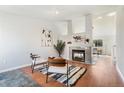 Bright living room with a cozy fireplace, stylish seating arrangement, hardwood floors, and neutral decor at 5207 S Jericho Way, Centennial, CO 80015