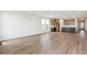 Bright, open-concept living space with wood floors leading to a modern kitchen, enhanced by natural light at 6384 E 154Th Pl, Thornton, CO 80602