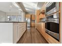 Beautiful kitchen featuring a large island, wooden cabinets, stainless steel appliances, and hardwood floors at 1622 W 67Th Ave, Denver, CO 80221