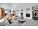 Open-concept living room with a fireplace, neutral tones, and ample natural light at 7511 S Sicily Way, Aurora, CO 80016