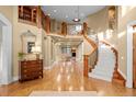 Grand foyer featuring a hardwood floor, elegant staircase, and bright lighting at 5 Redhawk Run, Cherry Hills Village, CO 80113