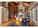 Elegant home library with floor-to-ceiling bookshelves, fireplace, and wooden ladder at 5 Redhawk Run, Cherry Hills Village, CO 80113