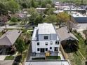 Aerial view of modern home in a residential neighborhood, featuring a rooftop deck, and fenced yard at 1541 Glencoe St, Denver, CO 80220
